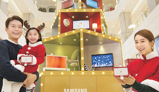 삼성전자 모델들이 29일 현대백화점 판교점 1층 광장에서 '크리스마스 선물 상자' 모양의 대형 '세리프 트리'를 소개하고 있다.  삼성전자 제공